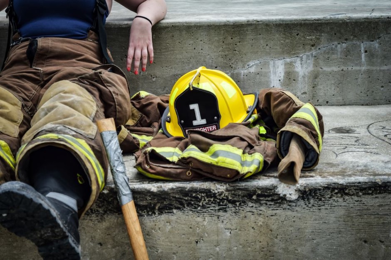 Close-up of a firefighter in full bunker gear holding a gas mask, ready for hazardous conditions