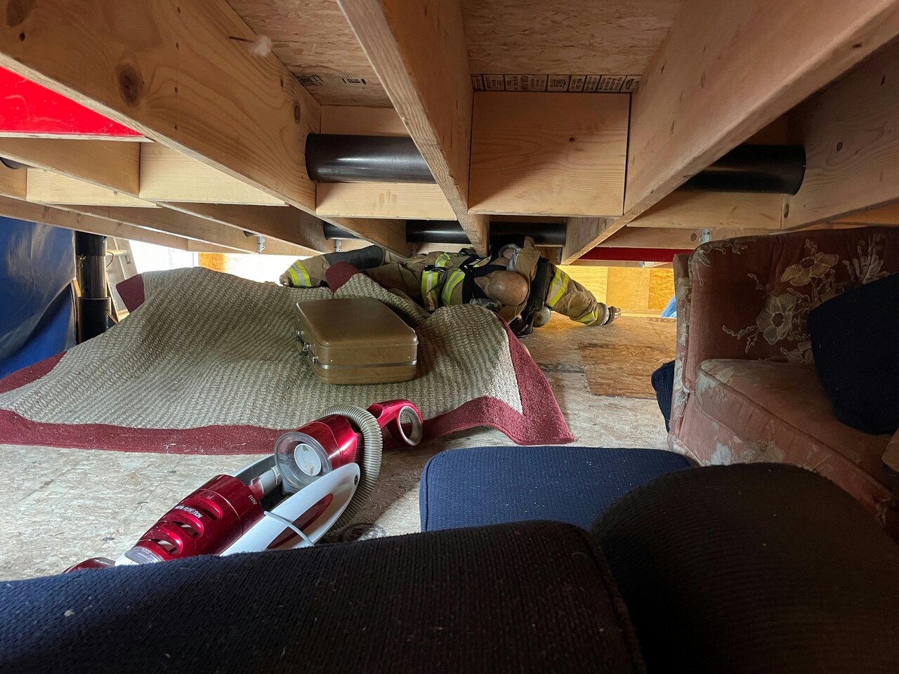 Rochester NY firefighter in turnout gear crawling into a void space during a structural collapse rescue drill