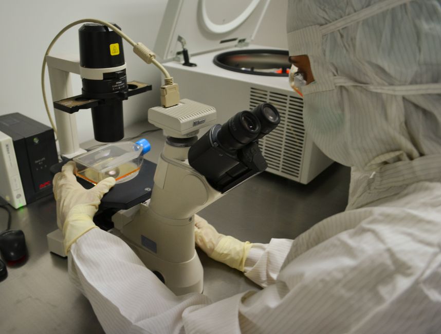 A worker inspecting industrial batteries inside a facility
